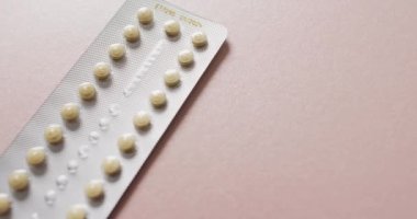 Pembe arka planda sarı tabletlerin yakın çekim videosu. küresel tıp ve sağlık konsepti.