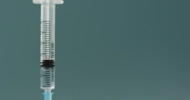 Video of close up of vaccine vials on green background. global medicine and healthcare concept.