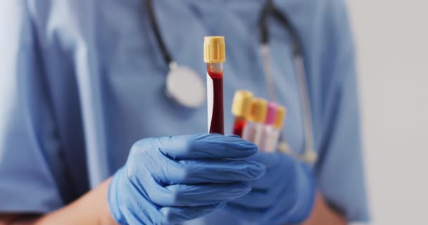 Video Biracial Female Doctor Holding Test Tubes Blue Background Global — Stok video