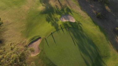Güneşli bir günde golf sahasında golf oynayan iki farklı erkek golfçü. sağlıklı ve aktif zaman.