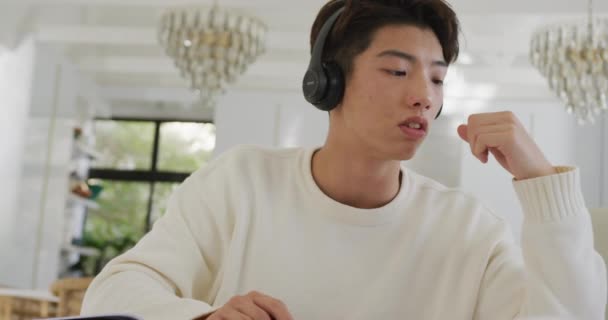 Asian Male Teenager Headphones Learning Using Laptop Living Room Spending — стокове відео