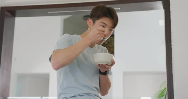 Asian Male Teenager Looking Away Having Breakfast Living Room Spending — стокове відео