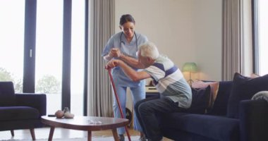 Kafkasyalı kıdemli adama karşı koymaya yardım eden mutlu melez kadın doktorun animasyonu. Yaşlılar sağlığı ve huzurevi konsepti dijital olarak oluşturulmuş video.