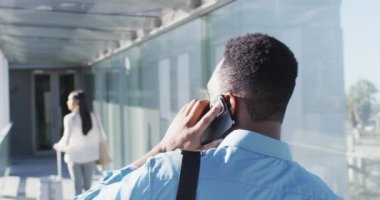 Afrika kökenli Amerikalı bir adamın akıllı telefon kullanarak yürüdüğünü gösteren bir video. İş adamları ve ofis kavramında çalışmak.