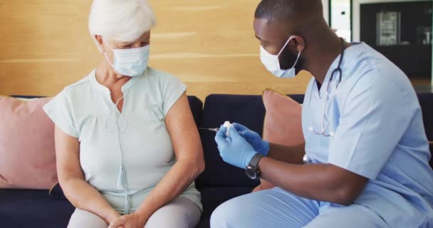 Video African American Male Doctor Face Mask Vaccinating Caucasian Senior — Stock Video