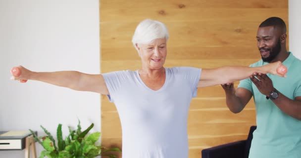 Video Happy African American Male Physiotherapist Examining Caucasian Senior Woman — Αρχείο Βίντεο