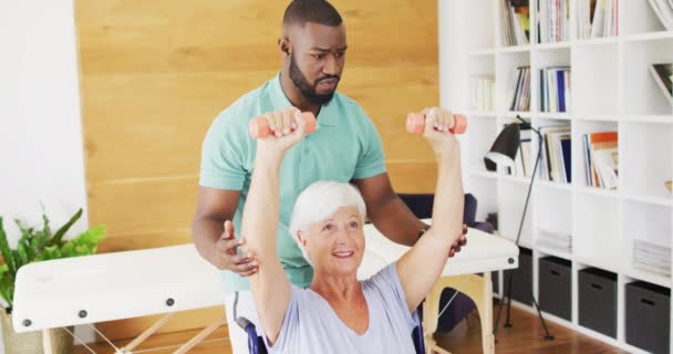 Video Happy African American Male Physiotherapist Exercising Caucasian Senior Woman — Αρχείο Βίντεο