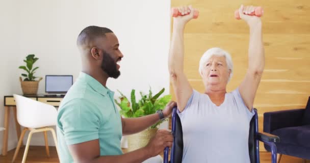 Видео Счастливого Африканского Американского Физиотерапевта Мужчины Тренирующегося Белой Пожилой Женщиной — стоковое видео