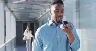 Afro-Amerikan bir adamın akıllı telefon kullandığını gösteren bir video. İş adamları ve ofis kavramında çalışmak.