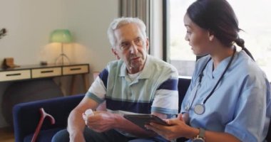 Kafkasyalı kıdemli bir adamla ilaçlardan bahseden mutlu, melez bir kadın doktorun animasyonu. Yaşlılar sağlığı ve huzurevi konsepti dijital olarak oluşturulmuş video.