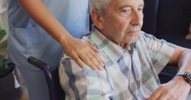 Kafkasyalı kıdemli bir adamla ilgilenen melez bir kadın doktorun orta bölüm videosu. Yaşlılar sağlık ve huzurevi konsepti.