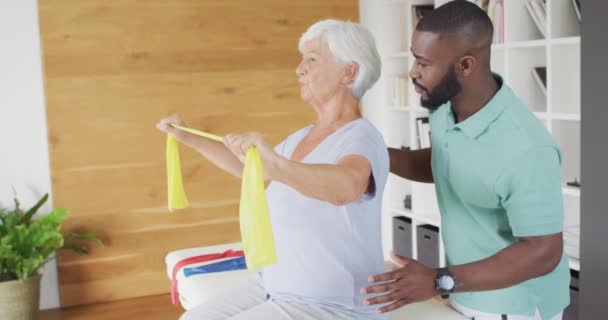 Video Happy Caucasian Senior Woman Exercising African American Male Physiotherapist — Αρχείο Βίντεο