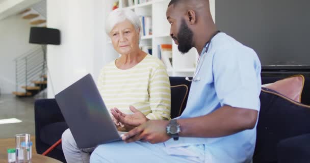 Video African American Male Doctor Using Laptop Caucasian Senior Woman — стокове відео