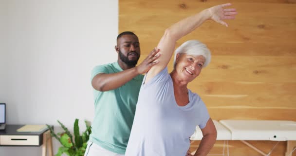 Video Feliz Afroamericana Fisioterapeuta Masculina Examinando Mujer Mayor Caucásica Ancianos — Vídeo de stock