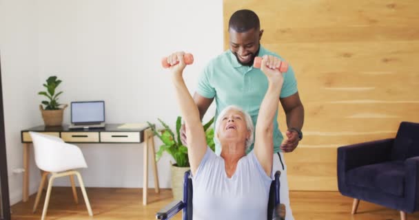 Video Happy African American Male Physiotherapist Exercising Caucasian Senior Woman — Wideo stockowe