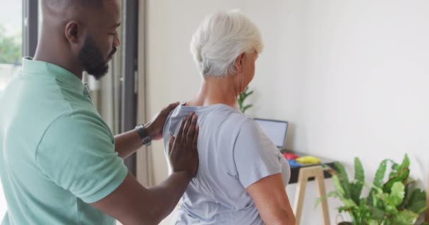 Video African American Male Physiotherapist Examining Caucasian Senior Woman Seniors — стокове відео