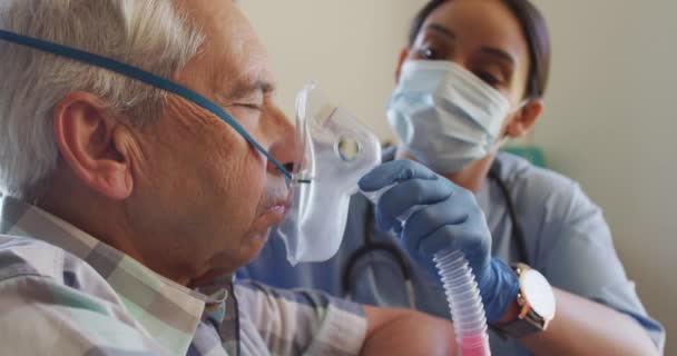 Video Biracial Female Doctor Face Mask Keeping Oxygen Caucasian Senior — Stock videók