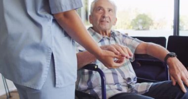 Kafkasyalı kıdemli bir adamla ilgilenen melez bir kadın doktorun orta bölüm videosu. Yaşlılar sağlık ve huzurevi konsepti.