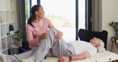 Kafkas kıdemli bir adamla egzersiz yapan mutlu kadın fizyoterapistin videosu. Yaşlılar sağlığı ve huzurevi konsepti dijital olarak oluşturulmuş video.