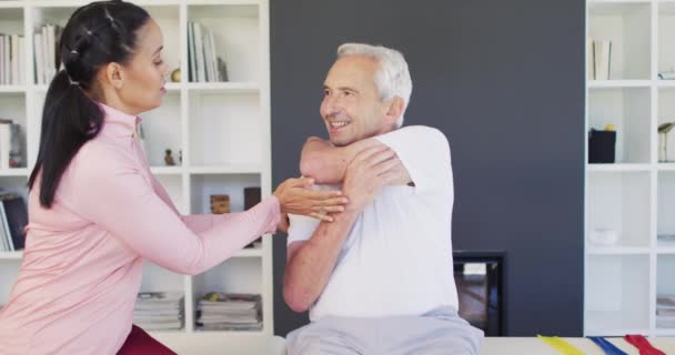 Video Glad Biracial Kvinnlig Sjukgymnast Utövar Med Kaukasiska Senior Man — Stockvideo