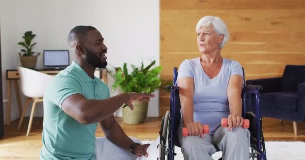 Video African American Male Physiotherapist Exercising Caucasian Senior Woman Seniors — Stockvideo