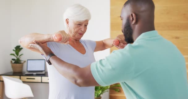 Video Happy African American Male Physiotherapist Examining Caucasian Senior Woman — Wideo stockowe