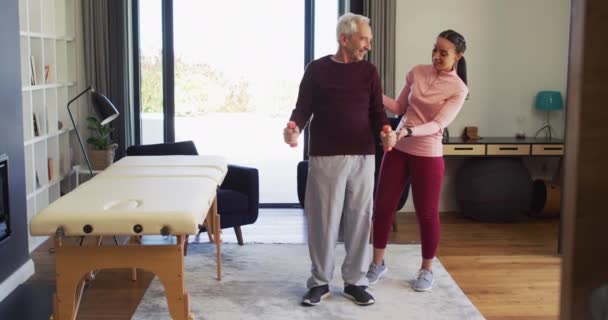 Video Happy Biracial Female Physiotherapist Exercising Caucasian Senior Man Seniors — Wideo stockowe