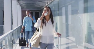 Çeşitli erkek ve kadınların bavulları ve kahveyle yürüdükleri bir video. İş adamları ve ofis kavramında çalışmak.