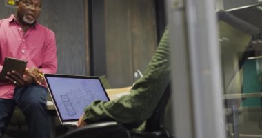 Tabletle çalışan ve konuşan farklı erkek ve kadın tasarımcıların videosu. İş adamları ve ofis kavramında çalışmak.