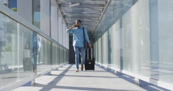 Video Hombre Afroamericano Caminando Con Una Maleta Usando Smartphone Profesionales — Vídeos de Stock