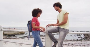 Sahilin yakınındaki gezinti alanında birbirleriyle konuşan Afrikalı Amerikalı genç bir çift. Aşk ve ilişki kavramı