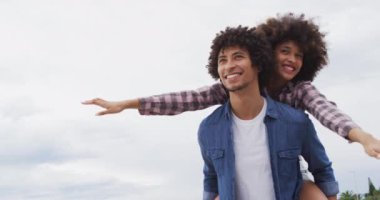 Afrikalı Amerikalı bir adam, sahil kenarındaki gezinti güvertesinde karısını sırtında taşıyor. Aşk ve ilişki kavramı