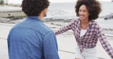 Afrika kökenli Amerikalı bir kadın sahildeki gezinti güvertesinde kocasına sarılıyor. Aşk ve ilişki kavramı