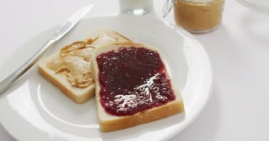 Close up view of peanut butter and jelly sandwiches in a plate on white surface. food and nutrition concept