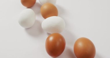 Close up view of brown and white eggs on white surface. food and nutrition concept