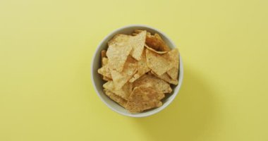 Sarı yüzeyinde fotokopi alanı olan bir kaseye nachos koy. yiyecek ve atıştırmalık konsepti