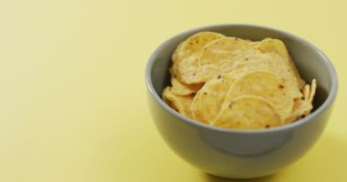 Sarı yüzeyinde fotokopi alanı olan bir kaseye çipleri yakın. yiyecek ve atıştırmalık konsepti