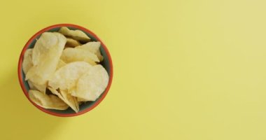Sarı yüzeyi fotokopi alanı olan bir kaseye patates cipsi koy. yiyecek ve atıştırmalık konsepti