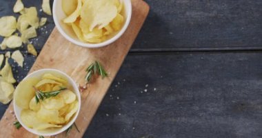 Tahta tepside iki kase patates cipsi ve ahşap yüzeyde fotokopi alanı. yiyecek ve atıştırmalık konsepti