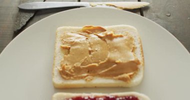 Close up view of peanut butter and jelly sandwiches in a plate on wooden surface. food and nutrition concept