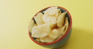 Sarı yüzeyi fotokopi alanı olan bir kaseye patates cipsi koy. yiyecek ve atıştırmalık konsepti