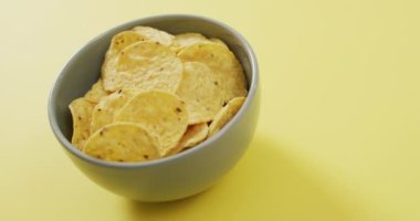 Sarı yüzeyinde fotokopi alanı olan bir kaseye çipleri yakın. yiyecek ve atıştırmalık konsepti