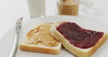 Close up view of peanut butter and jelly sandwiches in a plate with copy space on white surface. food and nutrition concept