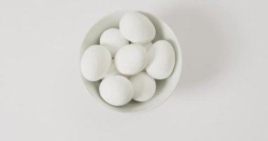 Close up of bowl of white eggs with copy space on white surface. organic food and nutrition concept