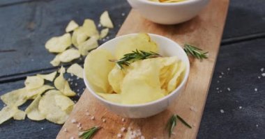 Tahta tepside iki kase patates cipsi ve ahşap yüzeyde fotokopi alanı. yiyecek ve atıştırmalık konsepti