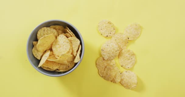 Sluiten Van Aardappelchips Een Kom Geel Oppervlak Voedsel Snackconcept — Stockvideo