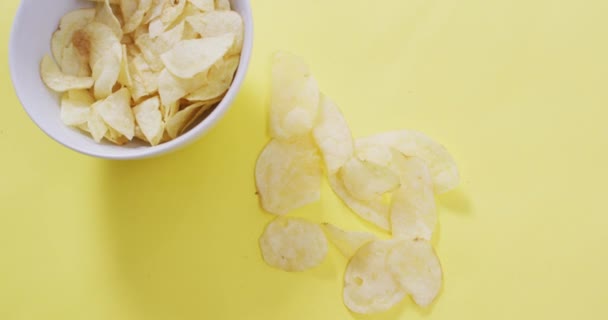 Sluiten Van Aardappelchips Vallen Een Kom Geel Oppervlak Voedsel Snackconcept — Stockvideo