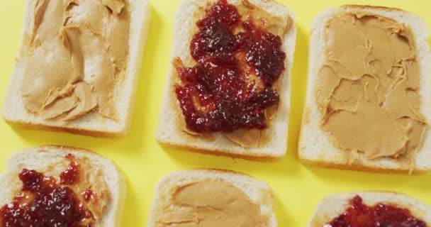 Cierre Múltiples Sándwiches Mantequilla Maní Jalea Superficie Amarilla Concepto Alimentación — Vídeo de stock