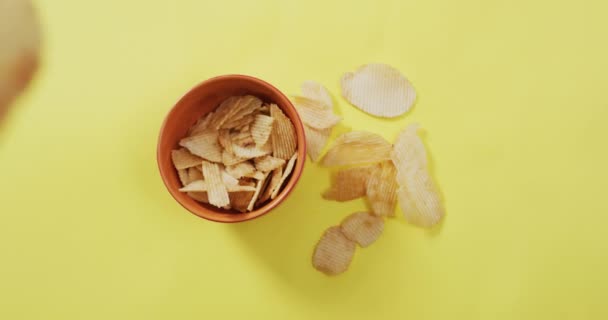 Close Potato Chips Falling Bowl Yellow Surface Food Snack Concept — Stockvideo