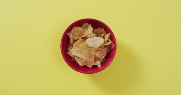 将薯片放入碗中 在黄色表面留有复制空间 食品和小吃概念 — 图库视频影像